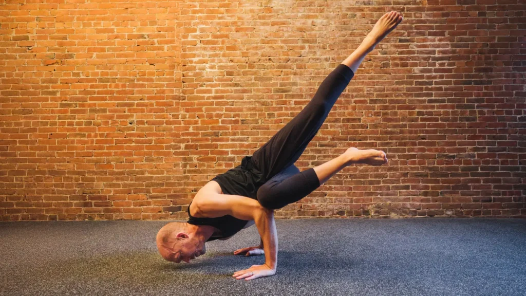 man doing a yoga pose at the gym